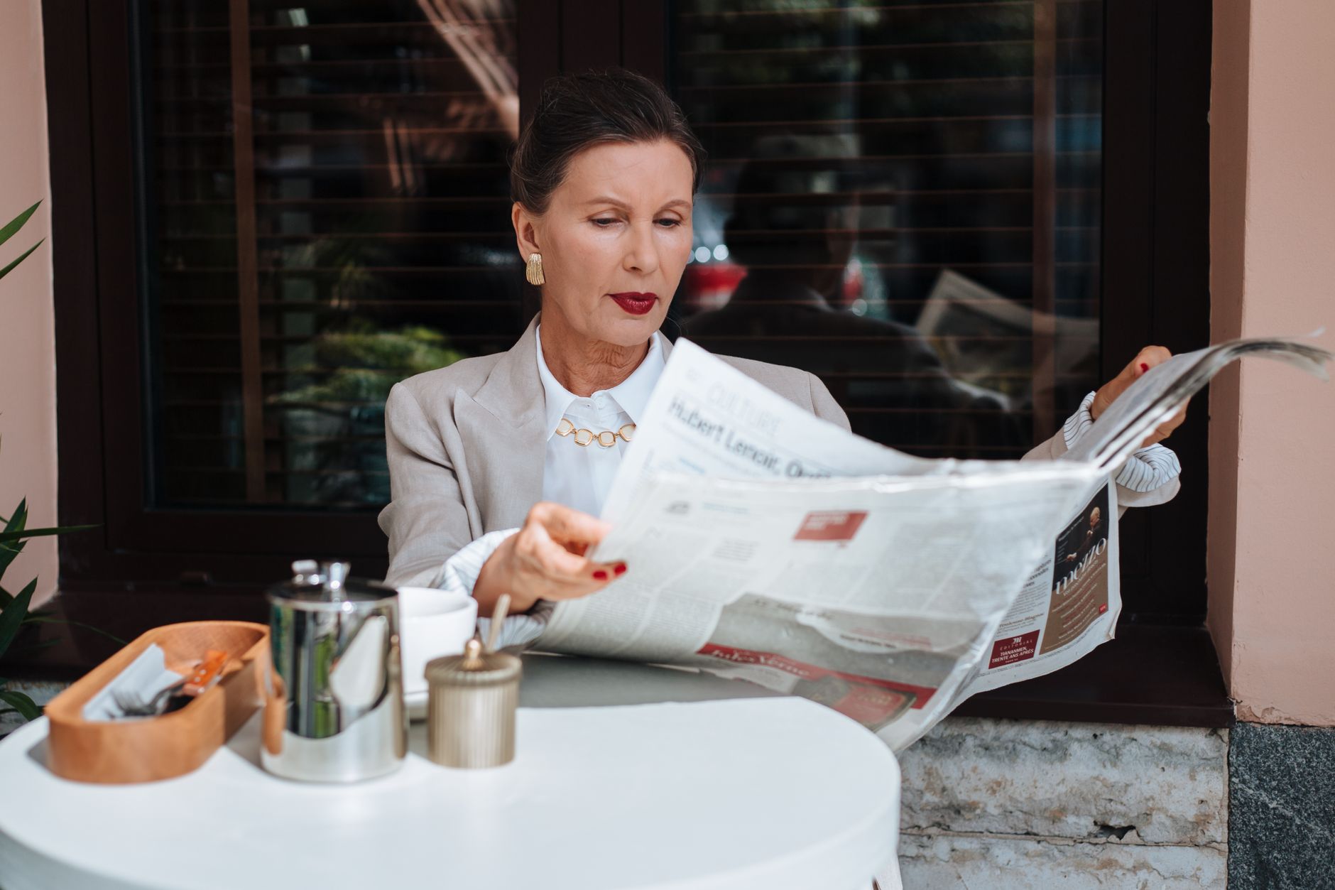 Sophisticated woman enjoying her morning newspaper at a cozy outdoor cafe. — Die Top-Spieleanbieter hinter GGBet Casino verst